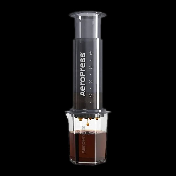 Zdjęcie czarnego zaparzacza AeroPress XL, umieszczonego na szklance, pokazującego proces parzenia kawy. Krople kawy delikatnie spadają do kubka, podkreślając wyjątkową metodę parzenia metodą AeroPress, z większym korpusem dla większej ilości kawy.