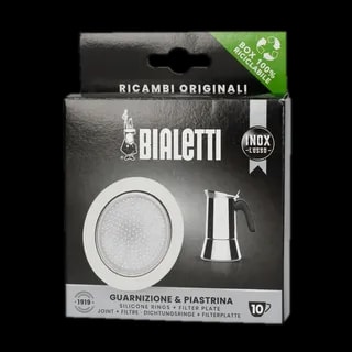 Opakowanie oryginalnego zestawu uszczelek i filtra do kawiarek stalowych Bialetti INOX LUSSO o rozmiarze 10 Tz. Produkt zawiera trzy silikonowe uszczelki oraz filtr z otworami, które są przeznaczone do kawiarek ze stali nierdzewnej Bialetti. Opakowanie w czarnym kolorze z białymi elementami, posiada logo Bialetti oraz zdjęcie kawiarki stalowej. Na górze opakowania widnieje informacja o 100% recyklingowalnym pudełku. Zestaw zapewnia wysoką jakość parzenia kawy i jest idealnym wyborem dla miłośników kawiarek Bialetti.