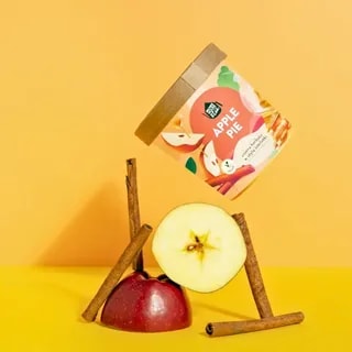 Na zdjęciu widoczny jest słoik herbaty smakowej Apple Pie, otoczony składnikami takich jak jabłka i cynamon. Produkt idealnie komponuje się z codziennym rytuałem picia herbaty, oferując unikalne połączenie smaków, które zadowoli każdego miłośnika aromatycznych naparów.