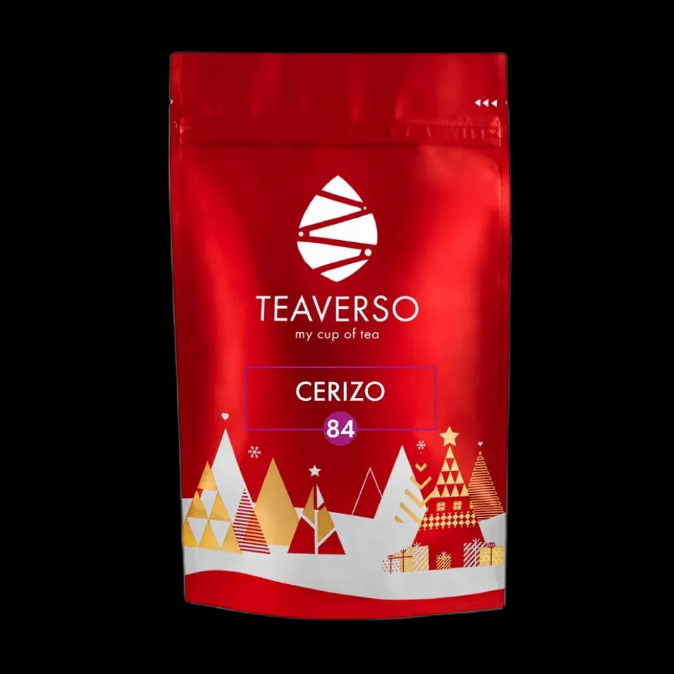 Opakowanie herbaty Teaverso Cerizo z numerem 84, w eleganckiej czerwonej torebce z zimowymi dekoracjami przedstawiającymi choinki, prezenty i gwiazdki. Idealna propozycja na świąteczny prezent lub zimowy wieczór.