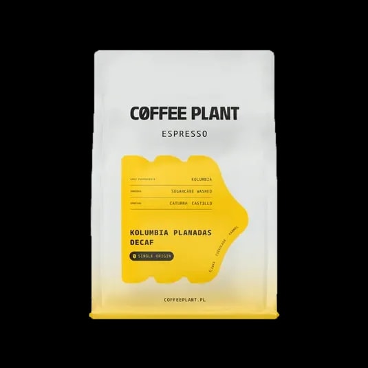 Opakowanie kawy bezkofeinowej Coffee Plant Kolumbia Planadas Decaf Espresso o wadze 250 g. Białe opakowanie z żółtą etykietą zawiera informacje o pochodzeniu kawy z Kolumbii, metodzie przetwarzania Sugarcane Washed oraz odmianach Caturra i Castillo.