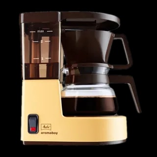 Ekspres przelewowy Melitta Aromaboy w kolorze beżowym, na białym tle. Kompaktowy design, idealny do parzenia 2 filiżanek kawy, wyposażony w szklany dzbanek, wskaźnik poziomu wody oraz funkcję automatycznego wyłączania