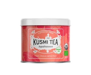 Metalowa puszka herbaty Kusmi Tea AquaSummer o pojemności 100 g w odcieniach koralowego z delikatnym roślinnym wzorem, zawierająca organiczną herbatę bezkofeinową o smaku brzoskwini, hibiskusa i moreli.