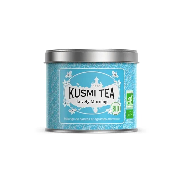 Opakowanie herbaty Kusmi Tea Lovely Morning w kolorze niebieskim, z etykietą informującą o składnikach i certyfikatach ekologicznych. Ta aromatyczna mieszanka ziołowa z dodatkiem cytrusów to idealny wybór na poranny relaks oraz wzmocnienie energii każdego dnia.