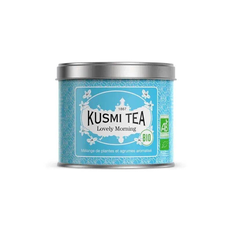 Opakowanie herbaty Kusmi Tea Lovely Morning w kolorze niebieskim, z etykietą informującą o składnikach i certyfikatach ekologicznych. Ta aromatyczna mieszanka ziołowa z dodatkiem cytrusów to idealny wybór na poranny relaks oraz wzmocnienie energii każdego dnia.