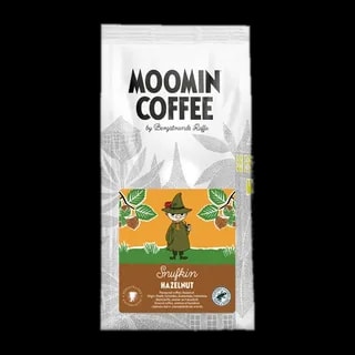 Opakowanie kawy Moomin Coffee Snufkin Hazelnut 250g z postacią Snufkina na etykiecie, otoczoną orzechami laskowymi na tle w stylu Moominów. Kawa smakowa z dodatkiem orzechów laskowych.