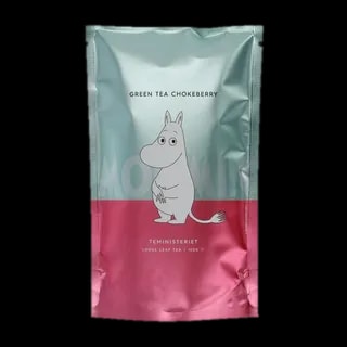 Opakowanie zielonej herbaty liściastej Moomin Green Tea Chokeberry od Teministeriet o pojemności 100g. Torba ma elegancką kombinację kolorów mięty i różu z minimalistyczną ilustracją Muminka na tle napisu 'Moomin'. Produkt idealny dla fanów Muminków, oferujący wyjątkowe doznania smakowe.