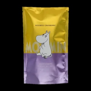 Opakowanie herbaty rooibos liściastej Moomin Rooibos Cranberry od Teministeriet o pojemności 100g. Srebrno-fioletowo-żółte opakowanie z wizerunkiem Muminka siedzącego na ziemi, trzymającego łapki na brzuchu, w minimalistycznym stylu. Herbata o smaku żurawiny, idealna dla fanów herbaty i wielbicieli Muminków.