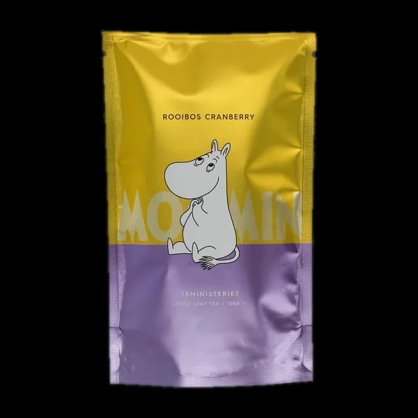 Opakowanie herbaty rooibos liściastej Moomin Rooibos Cranberry od Teministeriet o pojemności 100g. Srebrno-fioletowo-żółte opakowanie z wizerunkiem Muminka siedzącego na ziemi, trzymającego łapki na brzuchu, w minimalistycznym stylu. Herbata o smaku żurawiny, idealna dla fanów herbaty i wielbicieli Muminków.