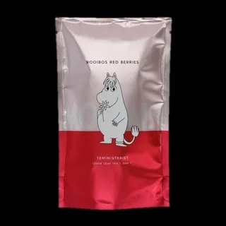 Opakowanie herbaty rooibos liściastej Moomin Rooibos Red Berries od Teministeriet o pojemności 100g. Srebrno-czerwone opakowanie z wizerunkiem uroczego Muminka trzymającego kwiatek, minimalistycznym designem i napisem 'Moomin'. Herbata o bogatym smaku czerwonych jagód, dedykowana wielbicielom herbaty i świata Muminków.