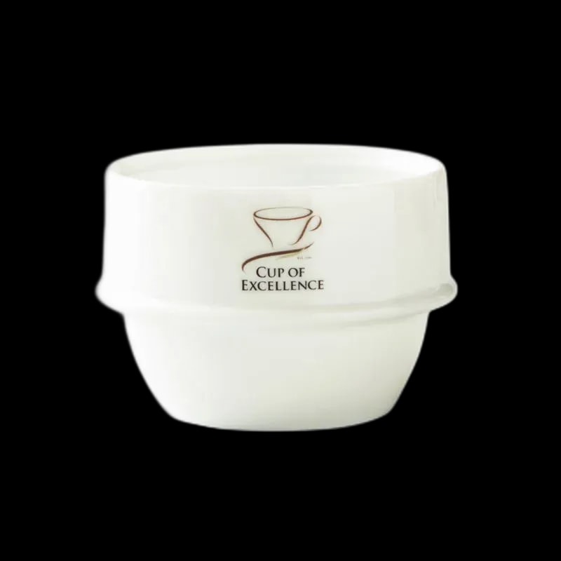 Biała miseczka cuppingowa Origami z logo Cup of Excellence, stworzona z wysokiej jakości ceramiki. Idealna do profesjonalnych degustacji kawy, zapewniająca doskonałe właściwości termiczne i precyzyjne testowanie aromatu oraz smaku kawy.