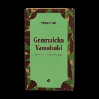 Japońska herbata zielona Teasome Genmaicha Yamabuki z regionów Kagoshima i Hokkaido została zapakowana w charakterystyczne zielono-brązowe pudełko z botanicznym wzorem. Zawiera mieszankę zielonej herbaty z prażonym ryżem, oferując łagodny, lekko orzechowy napar o tradycyjnym smaku.