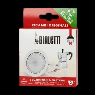 Opakowanie zawierające zestaw trzech uszczelek i sitko do kawiarek aluminiowych marki Bialetti, model 2 tz. Na zdjęciu widoczne jest pudełko z logiem Bialetti oraz rysunkiem kawiarki, a także informacją o zawartości - trzy gumowe uszczelki oraz metalowe sitko filtrujące. Zestaw przeznaczony do kawiarek aluminiowych, zapewnia dłuższą żywotność urządzenia oraz lepszą jakość parzenia kawy. Produkt jest zapakowany w ekologiczne opakowanie, w pełni nadające się do recyklingu.