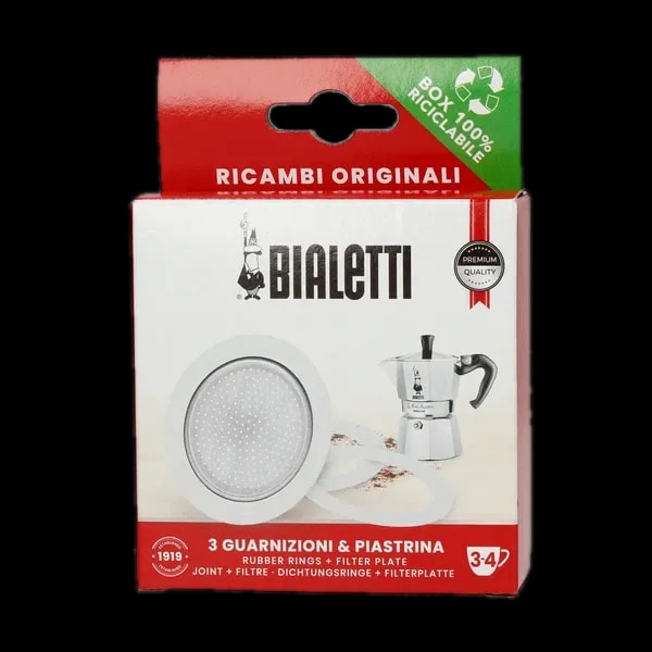 Zdjęcie zestawu uszczelek i sitek do kawiarek aluminiowych Bialetti 3-4 tz. Opakowanie zawiera trzy uszczelki gumowe i jedno sitko filtrujące, które są przedstawione na białym tle. Opakowanie w czerwono-białej kolorystyce z logotypem Bialetti oraz informacją o zawartości zestawu. Idealne do wymiany zużytych części w kawiarce, zapewniając długotrwałą jakość i doskonały smak kawy. Produkt ekologiczny, opakowanie w 100% nadające się do recyklingu.