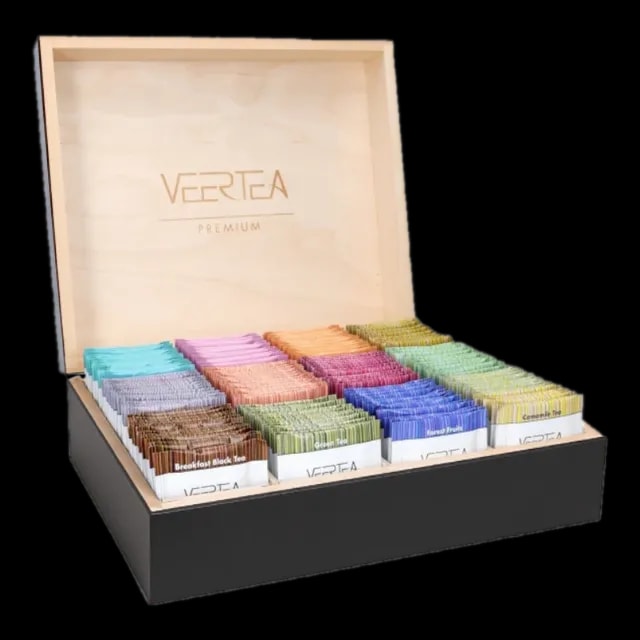 Luksusowa drewniana skrzynka VEERTEA Premium z różnokolorowymi herbatami, zawierająca różne smaki takie jak Breakfast Black Tea, Green Tea, i Flower Fruit, prezentowana na czarnym podłożu