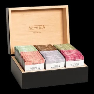 Skrzynka prezentowa VEERTEA Premium z drewna, wypełniona różnokolorowymi paczkami herbat, w tym smaki jak Citrus Tea, Earl Grey, oraz Cranberry & Raspberry, prezentowana na czarnym tle