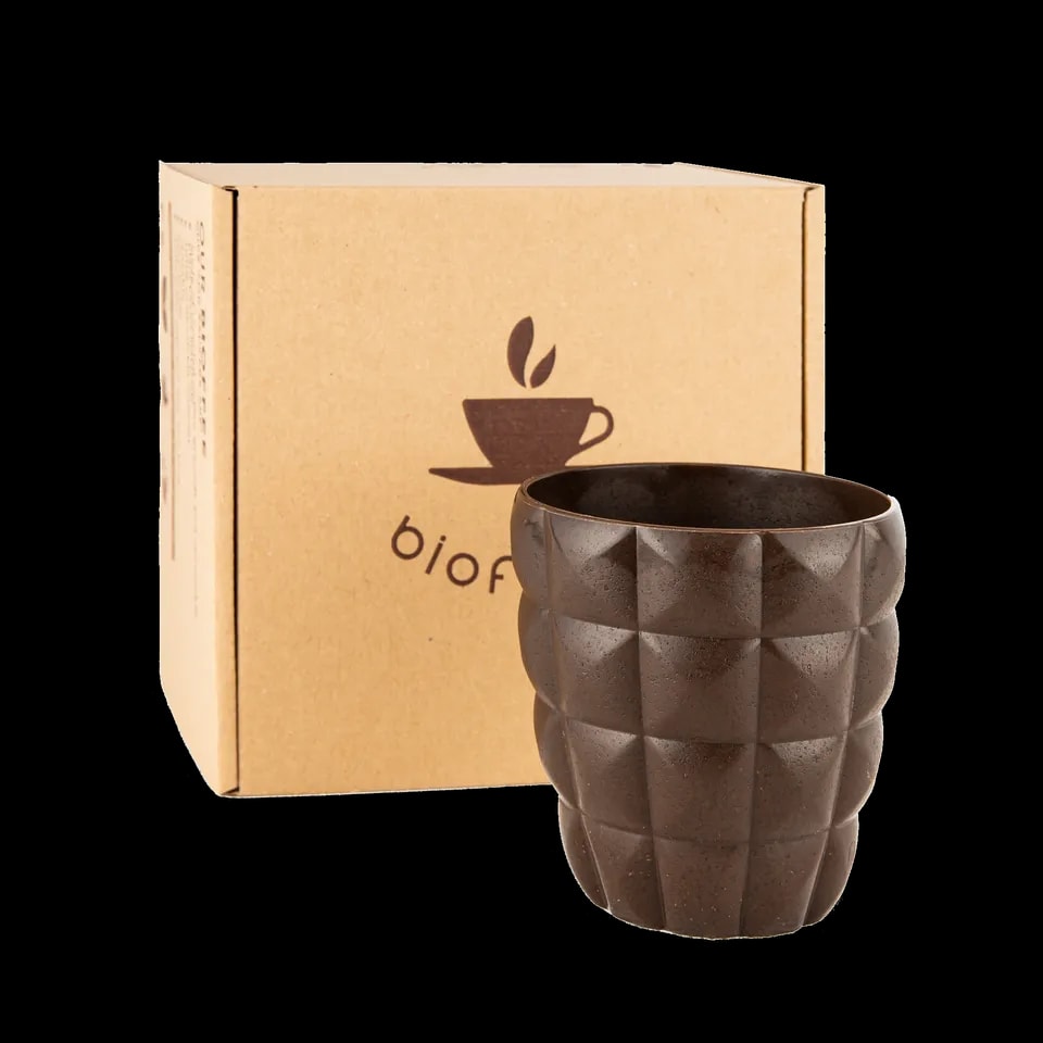 Granatowy kubek Bioffee z ekologicznych materiałów, stojący obok opakowania z logo Bioffee
