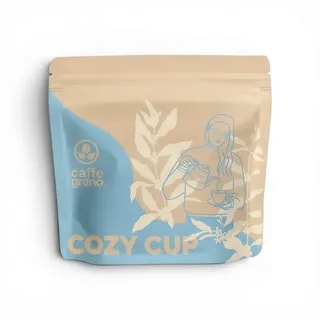 Opakowanie kawy Cozy Cup przedstawia unikalny design z rysunkiem parzącej osobie, co podkreśla jej przytulny charakter. Idealna do przygotowania aromatycznego napoju, zapewnia doskonałe doznania smakowe dla miłośników kawy.