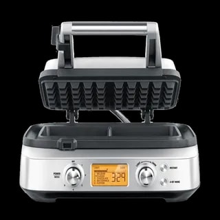 Gofrownica SAGE Smart Waffle SWM620 z otwartą pokrywą, gotowa do pieczenia gofrów. Urządzenie posiada cyfrowy wyświetlacz i pokrętła do ustawiania stopnia wypieczenia oraz wyboru rodzaju gofrów. Elegancka obudowa w srebrnym kolorze, wykonana ze stali nierdzewnej.