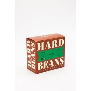 Na zdjęciu widoczna jest elegancka paczka kawy brazylijskiej od Hard Beans, przeznaczona do parzenia espresso. Opakowanie w intensywnych kolorach i nowoczesnym designie doskonale oddaje charakter wysokiej jakości kawy, idealnej dla prawdziwych koneserów.