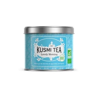 Opakowanie herbaty Kusmi Tea Lovely Morning w kolorze niebieskim, z etykietą informującą o składnikach i certyfikatach ekologicznych. Ta aromatyczna mieszanka ziołowa z dodatkiem cytrusów to idealny wybór na poranny relaks oraz wzmocnienie energii każdego dnia.