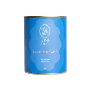 Opakowanie Lune Tea Blue Matcha z różowym akcentem i złotą obręczą, zawierające 40g proszku z kwiatu Klitorii Ternateńskiej. Idealne do przygotowania zdrowych napojów, zachwyca intensywnym kolorem i unikalnym smakiem, doskonałe dla miłośników herbat i innowacyjnych naparów.