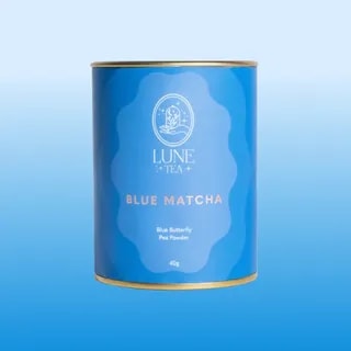 Opakowanie Lune Tea Blue Matcha z różowym akcentem i złotą obręczą, zawierające 40g proszku z kwiatu Klitorii Ternateńskiej. Idealne do przygotowania zdrowych napojów, zachwyca intensywnym kolorem i unikalnym smakiem, doskonałe dla miłośników herbat i innowacyjnych naparów.