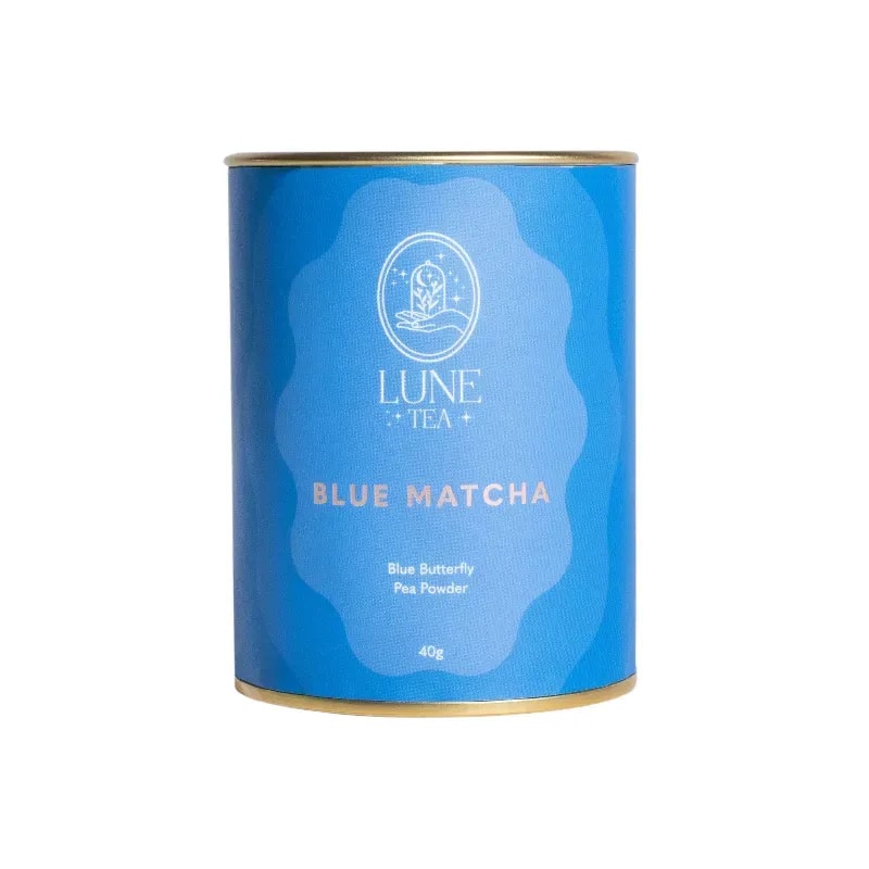 Opakowanie Lune Tea Blue Matcha z różowym akcentem i złotą obręczą, zawierające 40g proszku z kwiatu Klitorii Ternateńskiej. Idealne do przygotowania zdrowych napojów, zachwyca intensywnym kolorem i unikalnym smakiem, doskonałe dla miłośników herbat i innowacyjnych naparów.