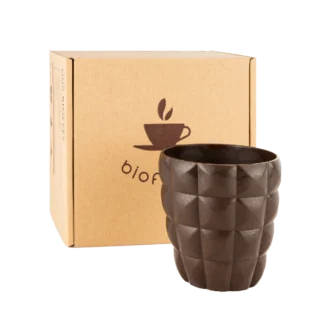 Granatowy kubek Bioffee z ekologicznych materiałów, stojący obok opakowania z logo Bioffee