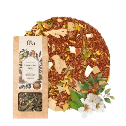 Herbata rooibos Egzotyczny Relax w ekologicznym opakowaniu, z dodatkiem skórki i kwiatu pomarańczy, limonki i eukaliptusa na tle białej miski wypełnionej herbatą. Obok leżą liście i kwiaty eukaliptusa.
