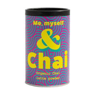 Kolorowe opakowanie Organic Chai Latte Powder marki Me, Myself & Chai. Cylindryczna puszka z intensywnym wzorem różowo-niebieskich fal oraz wyraźnym żółtym napisem 'Me, myself & Chai'. Zawiera organiczny proszek do przygotowania chai latte, idealny dla miłośników tej aromatycznej i korzennej herbaty.