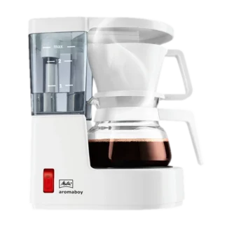 Ekspres przelewowy Melitta Aromaboy w kolorze białym, na białym tle. Kompaktowy design, idealny do parzenia 2 filiżanek kawy, wyposażony w szklany dzbanek, wskaźnik poziomu wody oraz funkcję automatycznego wyłączania, zapewnia wygodne i szybkie przygotowanie aromatycznej kawy