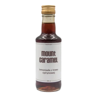 Mała przezroczysta butelka z ciemną lemoniadą 'Trawa Cytrynowa' Mount Carmel, ręcznie robiona, o pojemności 200 ml, z białą etykietą informującą o smaku i marce