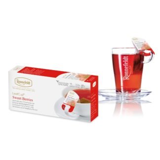 Opakowanie herbaty Ronnefeldt LeafCup Sweet Berries, zawierające 15 saszetek aromatyzowanej herbaty owocowej o smaku truskawek i malin, każda o wadze 3,2 g (48 g netto). Obok opakowania widoczna jest szklanka z gorącą herbatą z logo Ronnefeldt, z etykietą 'Sweet Berries'. Opakowanie jest w tonacji bieli i czerwieni, z grafiką przedstawiającą owoce.