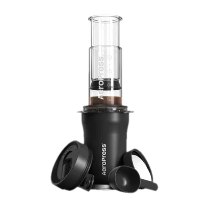 Zdjęcie AeroPress Go Plus w kolorze czarnym, prezentujące pełny zestaw do parzenia kawy, w tym prasa AeroPress, czarna miarka, pokrywka oraz pojemnik do przechowywania. Zestaw przeznaczony do łatwego przygotowywania kawy w podróży.