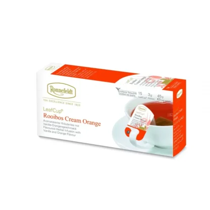 Opakowanie herbaty Ronnefeldt LeafCup Rooibos Cream Orange. Zawiera 15 saszetek herbaty liściastej o smaku Darjeeling Summer Gold. Widoczna filiżanka z zaparzoną herbatą i torebką Ronnefeldt. Na opakowaniu znajduje się logo marki, oraz informacje o gramaturze: 3g x 15 sztuk (45g netto).