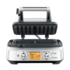 Gofrownica SAGE Smart Waffle SWM620 z otwartą pokrywą, gotowa do pieczenia gofrów. Urządzenie posiada cyfrowy wyświetlacz i pokrętła do ustawiania stopnia wypieczenia oraz wyboru rodzaju gofrów. Elegancka obudowa w srebrnym kolorze, wykonana ze stali nierdzewnej.