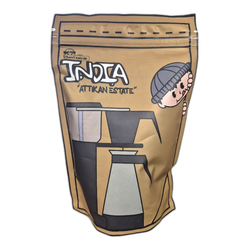 Opakowanie kawy ziarnistej Runty Roaster Indie "Attikan Estate" 250g. Wyjątkowa kawa speciality z plantacji Attikan Estate w Indiach, o delikatnych nutach karmelu, przypraw korzennych i czekolady. Idealna do alternatywnych metod parzenia, takich jak Chemex, V60 czy AeroPress. Doskonały wybór dla miłośników orientalnych smaków.
