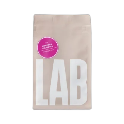Opakowanie kawy speciality CoffeeLab Gwatemala Finca La Pila w minimalistycznym beżowym designie z dużym białym napisem "LAB" i fioletową etykietą. Ta wyjątkowa kawa charakteryzuje się nutami lukrecji, jagód i piernika, oferując bogaty smak dla koneserów kawy filtrowanej.