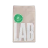 Beżowa torebka kawy ziarnistej Coffeelab Mjanma Padah Lin o pojemności 250 g. Na froncie duży biały napis „LAB” i zielone kółko z informacją o profilu smakowym: mirabelka, praliny, śliwka węgierka.