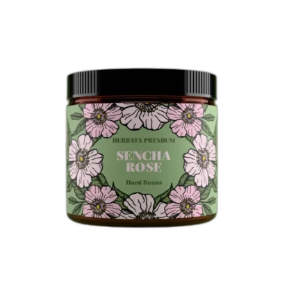 Szklany słoik herbaty zielonej Hard Beans „Sencha Rose” o pojemności 50 g. Zielona etykieta ozdobiona ilustracjami jasnoróżowych kwiatów i liści. W centralnej części widoczny napis „Herbata Premium – Sencha Rose – Hard Beans”.
