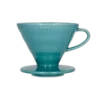 Stylowy ceramiczny dripper Hario V60-02 w turkusowym odcieniu, stworzony do precyzyjnego parzenia kawy metodą przelewową. Stożkowy kształt i spiralne żłobienia wewnętrzne zapewniają równomierną ekstrakcję, podkreślając głębię smaku świeżo mielonych ziaren.