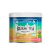 Puszka herbaty Kusmi Tea Happy Mind w energetycznych barwach niebieskiego, żółtego i pomarańczowego, z napisem „Caffeine Free” i informacją o składzie: moringa, imbir, kurkuma, aromat smoczego owocu.