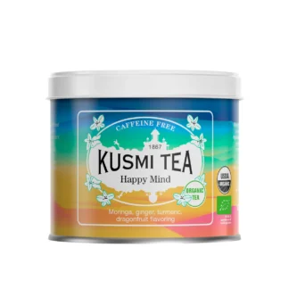 Puszka herbaty Kusmi Tea Happy Mind w energetycznych barwach niebieskiego, żółtego i pomarańczowego, z napisem „Caffeine Free” i informacją o składzie: moringa, imbir, kurkuma, aromat smoczego owocu.