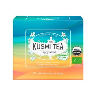 Kolorowe opakowanie herbaty Kusmi Tea Happy Mind w odcieniach turkusu, pomarańczu i żółci z napisem „Caffeine Free” oraz informacją o składnikach: moringa, imbir, kurkuma i aromat smoczego owocu.