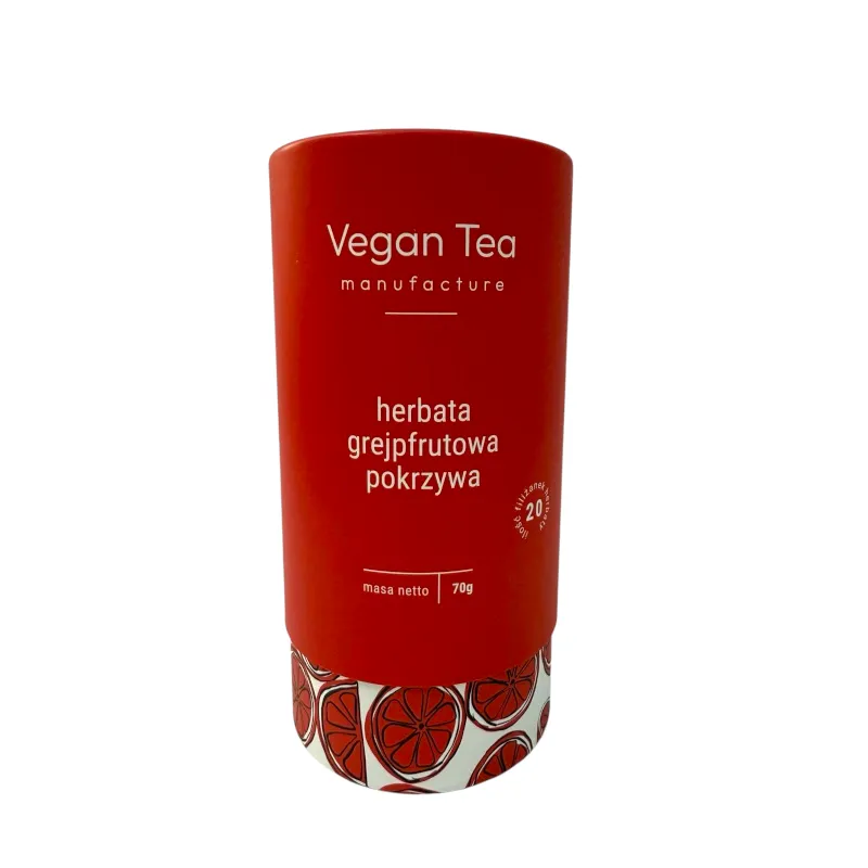 Cylindryczne czerwone opakowanie herbaty Vegan Tea z ilustracją plasterków grejpfruta u dołu. Na froncie widoczny biały napis: „herbata grejpfrutowa pokrzywa, masa netto 70g, 20 filiżanek naparu”. Naturalna mieszanka owocowo-ziołowa
