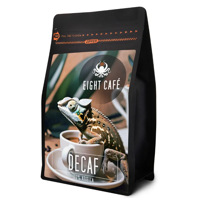 Opakowanie kawy bezkofeinowej Eight Café 100% Arabica, z kolorową grafiką przedstawiającą jaszczurkę i filiżankę kawy. Ten produkt to idealny wybór dla miłośników aromatycznej kawy, którzy pragną cieszyć się smakiem bez zawartości kofeiny.